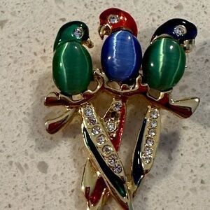 3 bird brooch in green and blue in gold tone. Pre owned has ones crystal missing